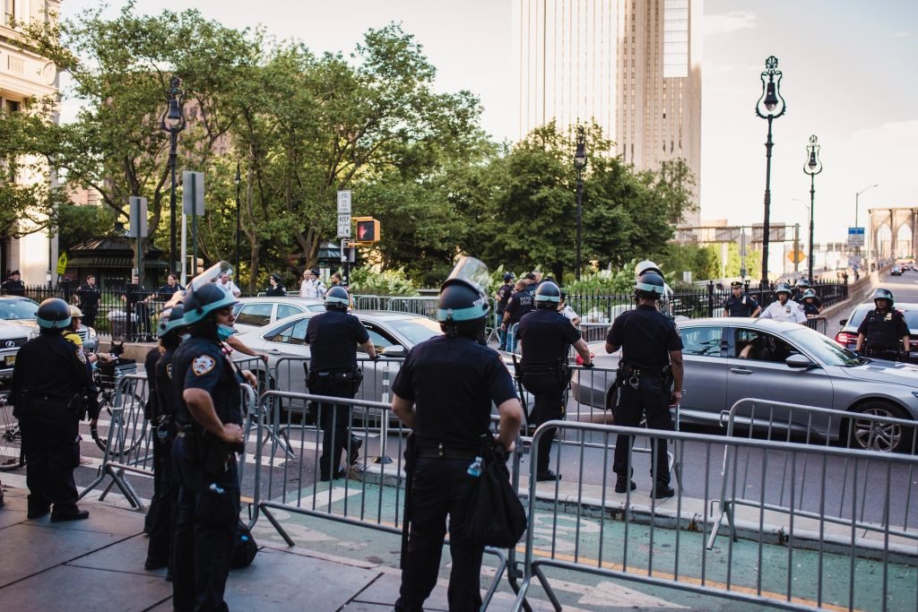 Policiais fardados e armados em operação na rua. Post: carreira de delegado de polícia. 