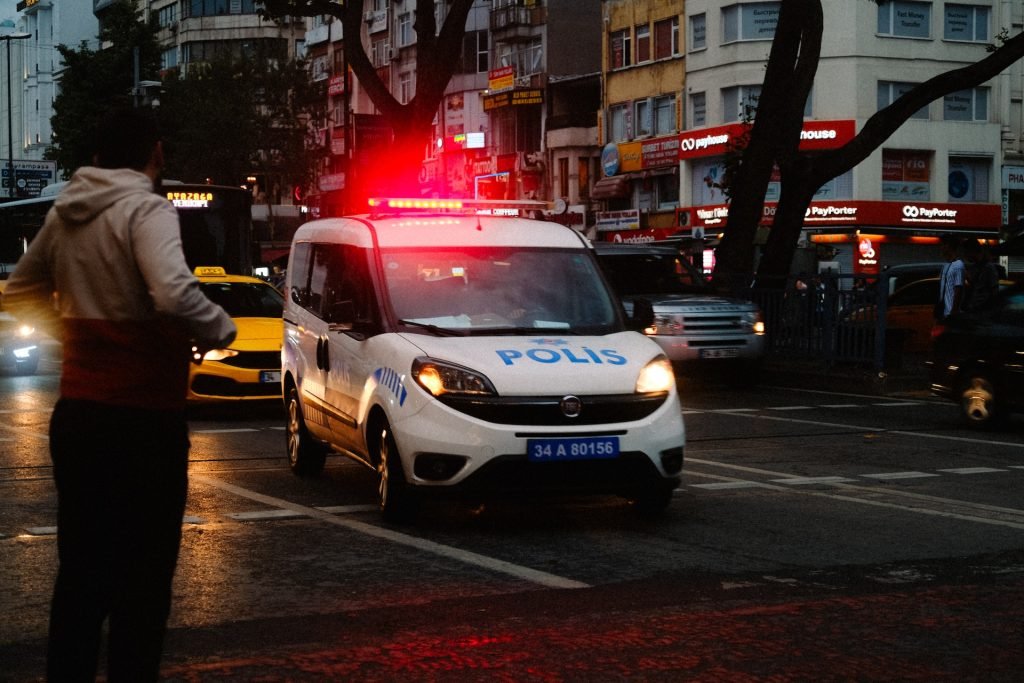 Viatura de polícia com sirene ligada em avenida, em concurso delegado Rio Grande do Sul.
